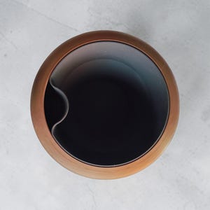 May include: A set of three ceramic mugs with a speckled, matte finish. The mugs are in shades of cream, light gray, and dark gray. Each mug has a simple, minimalist design, perfect for coffee or tea.