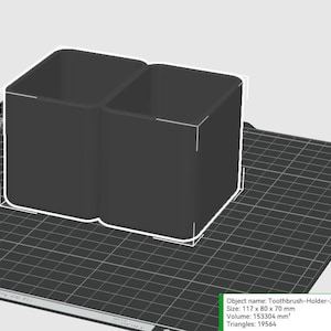 May include: A black, dual-compartment toothbrush holder. The holder is a rectangular shape with rounded corners and is approximately 4.6 inches wide, 3.1 inches deep, and 2.8 inches tall. The object is labeled "Toothbrush-Holder-2.stl".