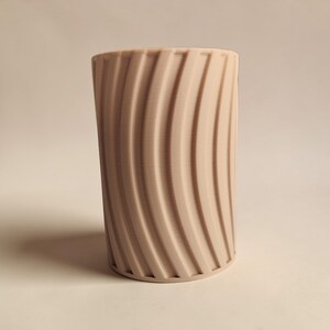May include: A set of three ceramic mugs with a speckled, matte finish. The mugs are in shades of cream, light gray, and dark gray. Each mug has a simple, minimalist design and a rounded handle.