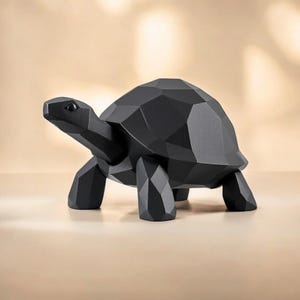 May include: A black geometric turtle sculpture with a faceted design. The turtle has a detailed head, four legs, and a shell. The sculpture is made of a solid material and is displayed on a neutral surface.