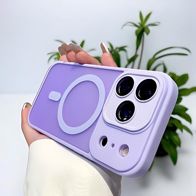 Puede incluir: Una funda de tel&eacute;fono lavanda con un dise&ntilde;o circular blanco y un m&oacute;dulo de c&aacute;mara. La funda tiene un borde elevado alrededor de las lentes de la c&aacute;mara y un acabado liso y mate. La funda est&aacute; dise&ntilde;ada para proteger la c&aacute;mara y el cuerpo del tel&eacute;fono.