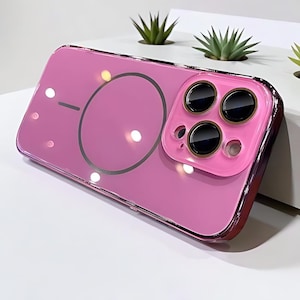 Op de afbeelding: Een roze telefoonhoesje met een heldere, glanzende afwerking. De hoes heeft een camera-uitsparing met drie zwarte lenzen en een cirkelvormig ontwerp op de achterkant. Het heeft een metallic, rood-paarse rand.