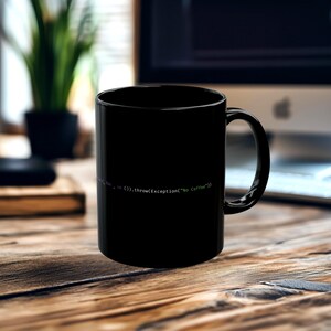 May include: A black coffee mug with a curved handle. The mug features a line of code in a light green font that reads: "...in ().throw(Exception("No Coffee"))". The mug is sitting on a wooden surface.