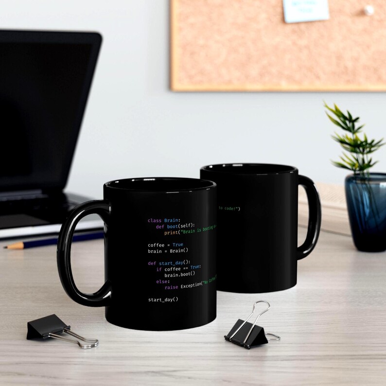 Op de afbeelding: Twee zwarte koffiemokken met witte tekst met Python-code. De code bevat "class Brain" en "coffee = True". E&eacute;n mok staat scherp, de andere is iets wazig. De mokken staan op een licht houten oppervlak.