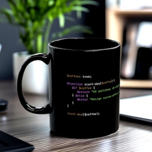 May include: Black coffee mug with white text that reads "$coffee: true; @function start-day($coffee) { @if $coffee { @return "UI polished. UX eng" } @else { @error "Design system offline" } } start-day($coffee);"