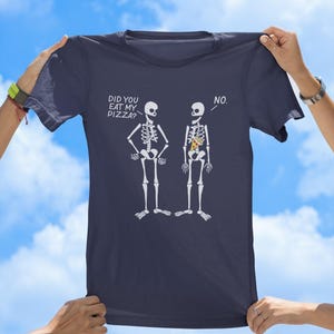 May include: A navy blue t-shirt with a graphic of two skeletons. One skeleton has a slice of pizza in its ribcage. The text on the shirt reads "Did you eat my pizza?" and "No."
