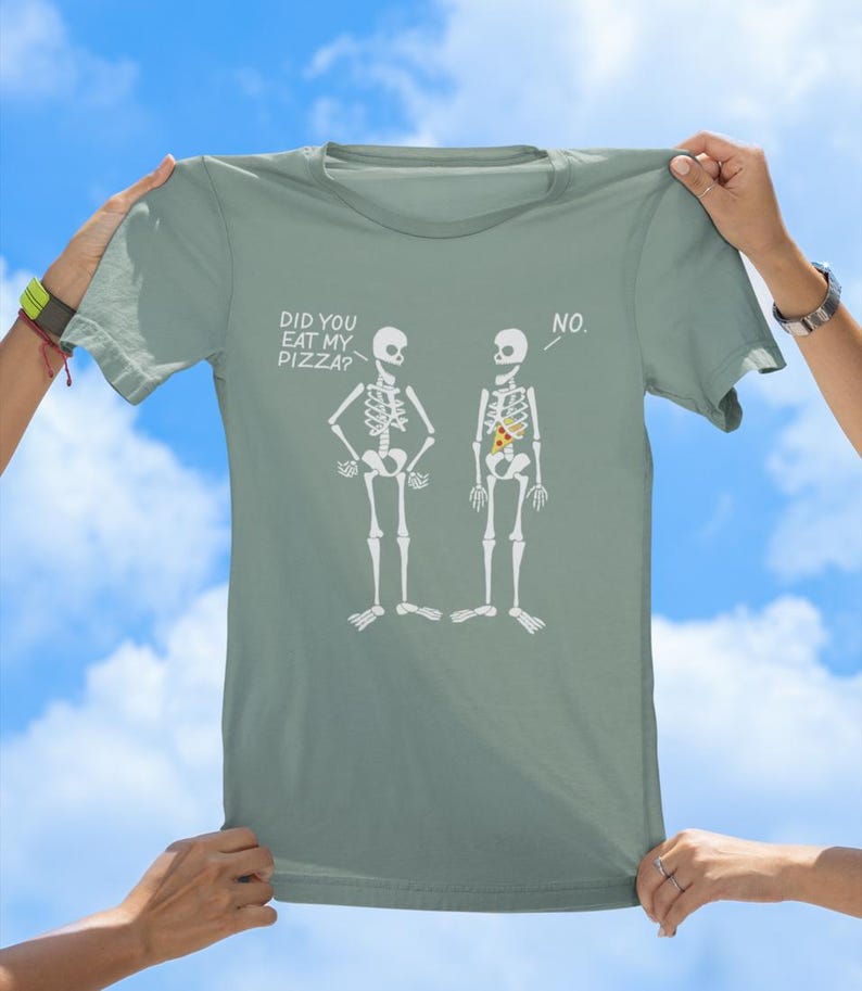 May include: A light green t-shirt with a humorous graphic of two skeletons. One skeleton asks "Did you eat my pizza?" and the other skeleton replies "No."