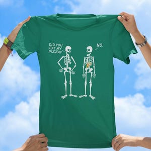 May include: A green t-shirt with a funny skeleton graphic. The text on the shirt reads "Did you eat my pizza?" and "No."