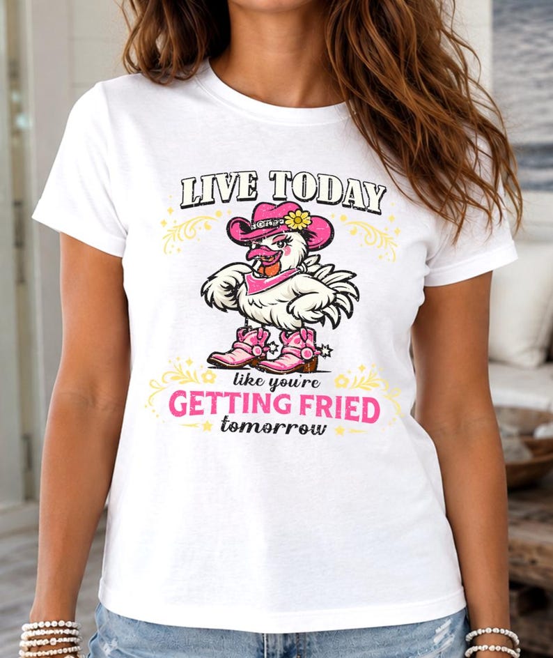 Puede incluir: Una camiseta blanca de manga corta con el gr&aacute;fico de un pollo que lleva un sombrero de vaquero rosa, un pa&ntilde;uelo rosa y botas de vaquero rosas. El texto dice: LIVE TODAY like you're GETTING FRIED tomorrow, con adornos decorativos amarillos.