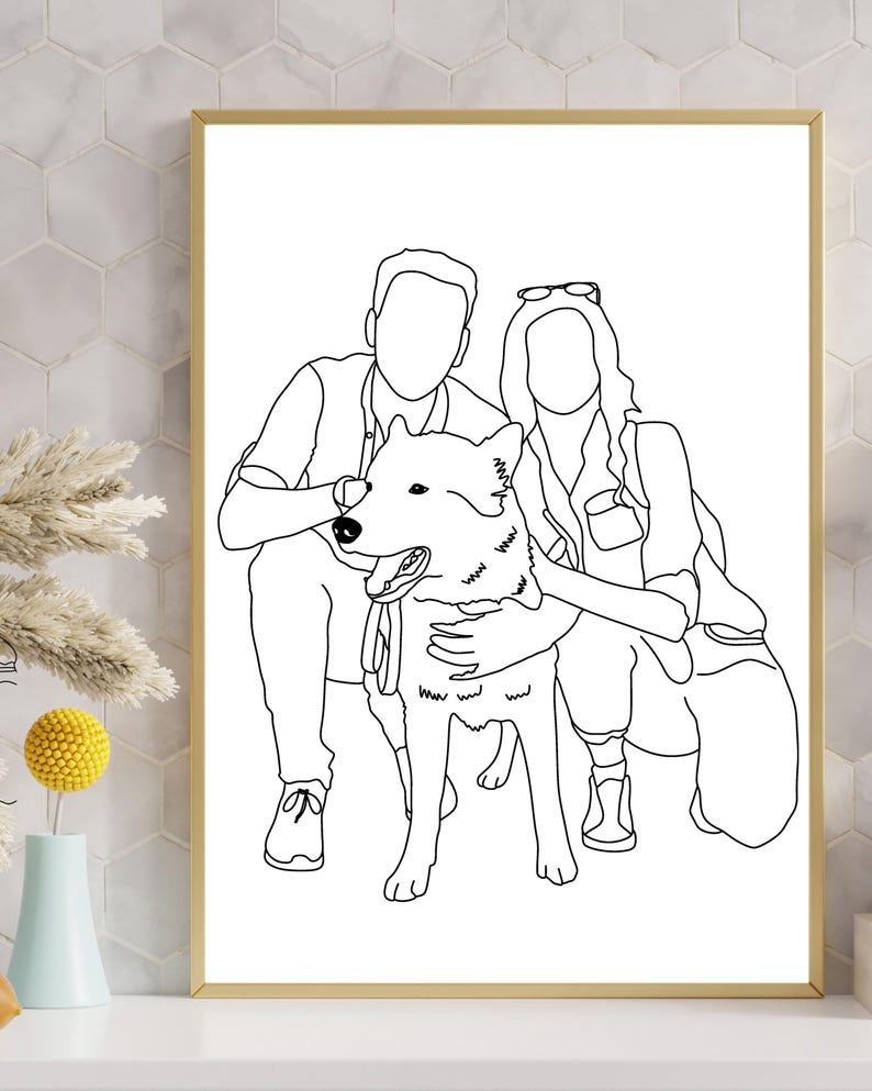 May include: A framed black and white line art print featuring a couple and their dog. The artwork depicts the couple embracing the dog, with the dog positioned in the center. The print is in a gold frame and is displayed on a white surface.