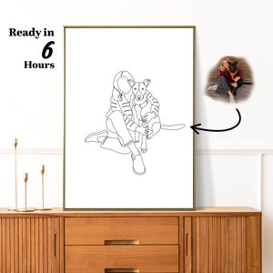 May include: A framed line art print featuring a person seated with a dog. The black and white illustration shows the person embracing the dog. The text "Ready in 6 Hours" is in the upper left corner. A smaller color photo of the dog and person is in the upper right.