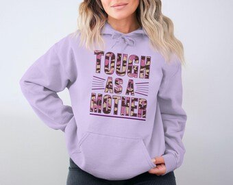 May include: A lavender hoodie with a pink and brown camouflage print that says "Tough as a Mother" in a bold font.