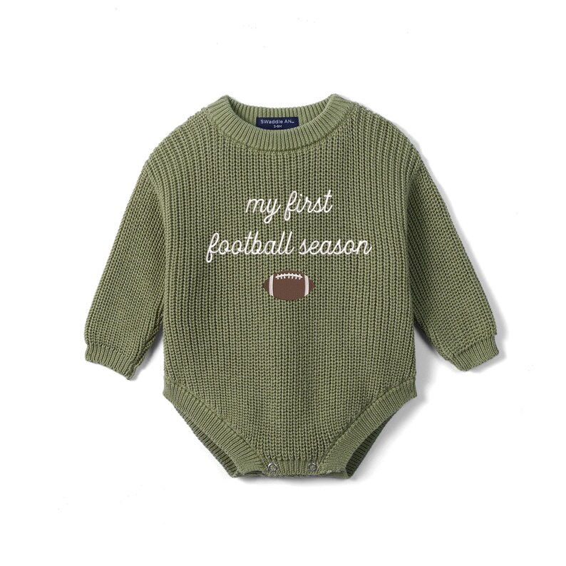 May include: An olive green long-sleeve knit romper featuring a crew neckline and ribbed texture. The front displays the white embroidered text 'my first football season' positioned above a brown and white graphic of an American football.