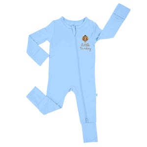 May include: A light blue baby sleeper with a full-length zipper. The sleeper features a cartoon turkey graphic with the words "little turkey" printed below it. The sleeper has long sleeves and foot coverings.