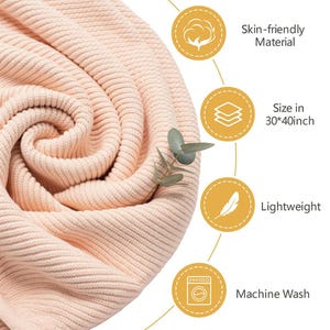 May include: A rolled-up, light peach-colored knitted blanket. The blanket is made of skin-friendly material and is lightweight. The size is 30 x 40 inches. The blanket is machine washable.