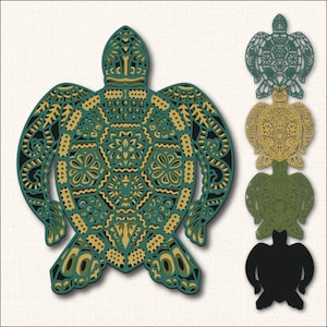 Op de afbeelding: Een gelaagd, decoratief zeeschildpadontwerp in tinten teal, goud en zwart. Het ingewikkelde patroon bevat geometrische en bloemelementen. Extra schildpaduitsparingen in groen, goud en zwart worden rechts weergegeven.