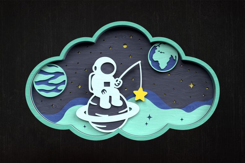 May include: A whimsical wooden art piece featuring an astronaut fishing for a yellow star from a planet. The design includes a blue and green cloud-shaped frame, planets, and stars against a dark background.