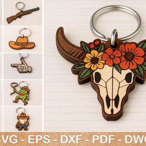 Könnte beinhalten: Ein Set mit 10 lasergeschnittenen Holz-Schlüsselanhängern. Die Designs umfassen einen Cowboyhut, ein Paar Stiefel, einen Schädel mit Blumen, einen Frosch, eine Gans, ein Paar Pistolen, eine Skeletthand und ein Paar Pistolen. Die Schlüsselanhänger sind aus Holz und lasergeschnitten.