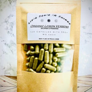 May include: A kraft paper pouch with a clear window displaying green capsules. The label reads "Liv's Tea's 'N Things" and "Organic Lemon Verbena" with details about the capsules. The best-by date is March 2028.