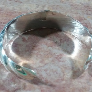 May include: Silver bracelet with a twisted design and a 925 stamp.