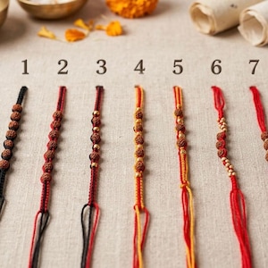 May include: Eight numbered bracelets arranged in a row, featuring various combinations of red, black, and orange braided cords adorned with brown textured beads, metallic gold-toned beads, and small light-colored wooden beads in different patterns.