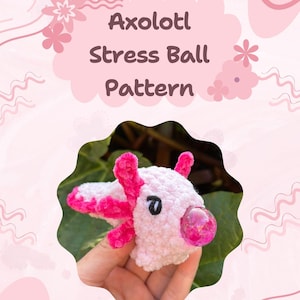 Op de afbeelding: Een wit en roze gehaakte axolotl stressbal. De axolotl heeft roze kieuwen, poten en een heldere, roze, belachtige neus. De afbeelding bevat de tekst "Axolotl Stress Ball Pattern" en "Pattern by Crochetedbylol".