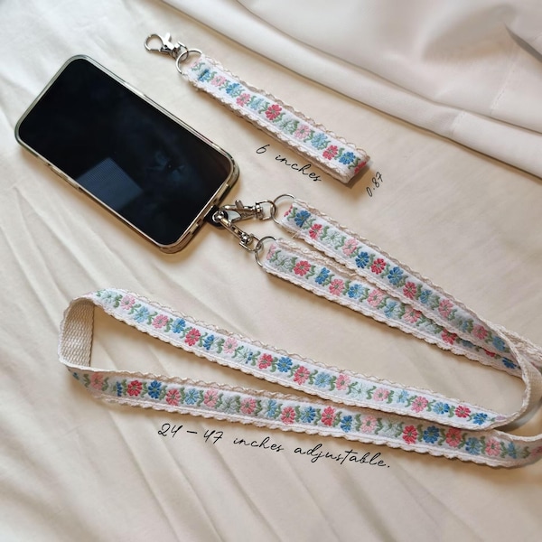 Set regalo con cinturino per cellulare a fantasia floreale / Set con tracolla regolabile e cordino da polso