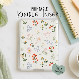 May include: A clear Kindle insert with a floral pattern featuring red, pink, and blue flowers on a cream background. The text "Printable Kindle Insert" is displayed above the insert. A digital download heart-shaped graphic is in the bottom right corner.