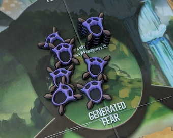 May include: A close-up of a board game with several purple and brown tokens. The tokens are shaped like stylized claws. The game board has text that reads "FEAR POOL" and "GENERATED FEAR".