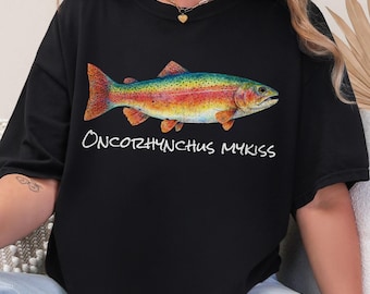 May include: Black t-shirt featuring a colorful illustration of a rainbow trout. The fish has orange, yellow, green, and blue hues. The text "Oncorhynchus mykiss" is written in white script below the fish.