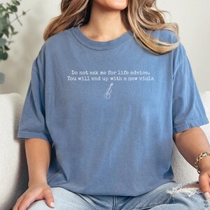 May include: A blue short-sleeved t-shirt featuring white text that reads, Do not ask me for life advice. You will end up with a new viola, accompanied by a small, simple white line drawing of a viola centered below the text.
