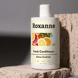 May include: White bottle of Roxanne Fresh Conditioner Citrus Cocktail. The bottle has a label with a citrus fruit design and the text "Fresh Conditioner Citrus Cocktail" and "250 ml - 12.5 fl oz".
