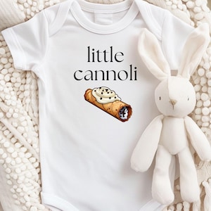 May include: White baby onesie with the text "little cannoli" and a cartoon image of a cannoli.