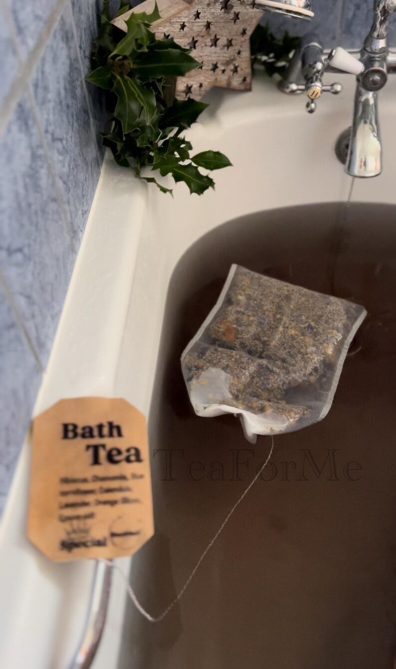 May include: A bath tea bag steeping in a bathtub. The bag contains herbs and flowers. A tag reads "Bath Tea" with the word "Special" at the bottom. The water is dark brown. The brand name "Tea For Me" is visible.