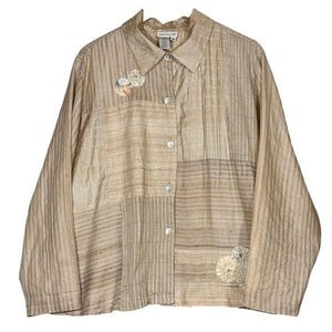 May include: Tan button-down shirt with long sleeves. The shirt features a patchwork design with vertical and horizontal stripes. Floral embroidery accents are on the front. The shirt has a collared neckline and is made of a lightweight fabric.