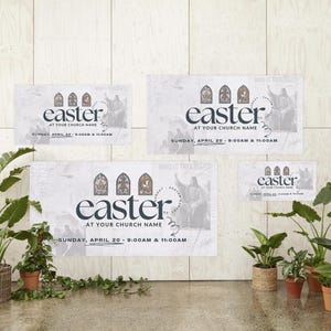 May include: Three white banners with the word "easter" in black text and a church steeple graphic. The banners also include the text "At Your Church Name" and the date and time of the event. The banners are displayed on a white wall with green plants in pots in the foreground.