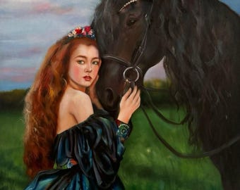 May include: A woman with long red hair wearing a blue dress and a floral crown is gently touching the head of a black horse. The horse is wearing a bridle and is standing in a field of green grass.