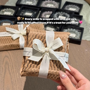 May include: A gift box wrapped in brown paper and tied with a white ribbon. The ribbon has the word "love" printed on it. The image text reads: "Every order is wrapped with love and care, ready to be gifted (even if it's a treat for yourself!)"