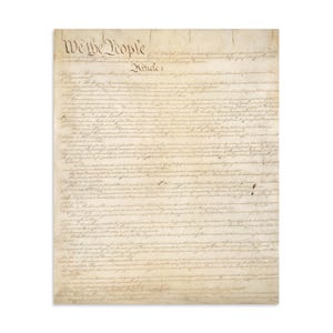 May include: A parchment-style document featuring the text of the United States Constitution, beginning with the large, stylized header We the People and Article 1, printed in dark brown ink on a textured, aged, light tan paper background.