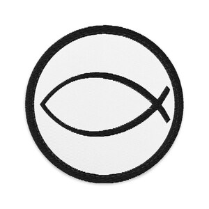May include: A circular embroidered patch featuring a white background with a black border. Centered on the patch is a black Christian fish symbol, also known as an ichthys, rendered in a simple, clean line art style with stitched texture.