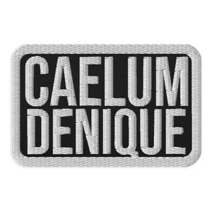 May include: A rectangular embroidered patch featuring a black background with the white text CAELUM DENIQUE in a bold, sans-serif font. The patch has a thick, white stitched border with rounded corners, creating a clean and defined edge.