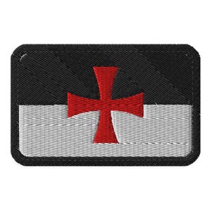 May include: Embroidered patch featuring a red cross on a black and white background. The patch has a rectangular shape with rounded corners and a stitched border. The cross is centered and prominent.
