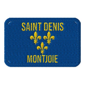 May include: A rectangular blue embroidered patch with rounded corners. The text SAINT DENIS is stitched in yellow thread at the top, followed by three yellow fleur-de-lis symbols arranged in a triangle, and the word MONTJOIE in yellow at the bottom.