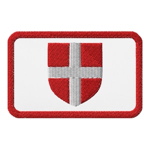 May include: A rectangular embroidered patch with a white background and a thick red border. Centered on the patch is a shield emblem featuring a red field divided by a white cross, creating a bold and clear graphic design element.