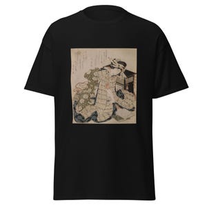 Könnte beinhalten: Schwarzes T-Shirt mit einem japanischen Vintage-Holzschnitt. Der Druck zeigt eine Frau in traditioneller Kleidung, die sitzt und liest. Das Kunstwerk verwendet gedämpfte Töne von Beige, Grün und Rot auf cremefarbenem Hintergrund.