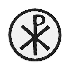 Könnte beinhalten: Ein kreisförmiger bestickter Aufnäher mit weißem Hintergrund und schwarzem Rand. In der Mitte ist ein schwarzes Chi-Rho-Symbol eingestickt, das aus den übereinandergelegten griechischen Buchstaben Chi und Rho besteht.