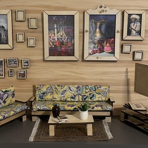 May include: Miniature living room set with a sofa, loveseat, coffee table, and TV stand. The sofa and loveseat have yellow floral cushions. Artwork and small picture frames are mounted on the wood-paneled wall. A small rug is under the coffee table.