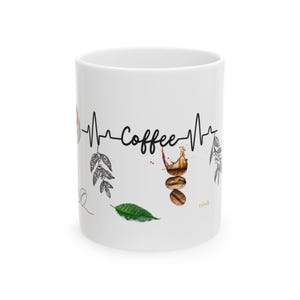 Könnte beinhalten: Weiße Keramik-Kaffeetasse mit einem schwarzen Herzschlag-Linien-Design und dem Wort "Coffee" in Schreibschrift. Die Tasse zeigt Kaffeebohnen, Blätter und ein Kaffeespritzer-Design. Eine stilvolle Tasse zum Thema Kaffee.