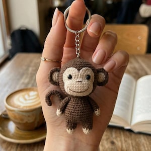 May include: A white ceramic mug with a black handle and the text "But First, Coffee" in a handwritten style. The mug is on a white surface. The mug is 4 inches tall.