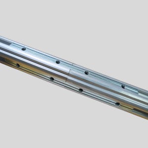 May include: Close-up of a section of a silver-colored metal linear rail system. The rail has multiple parallel tracks with evenly spaced holes. The system appears to be designed for precision movement or guidance in machinery or equipment.
